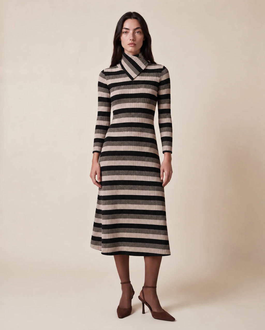 Vestido midi de rayas beige y negro con cuello alto y mangas largas.