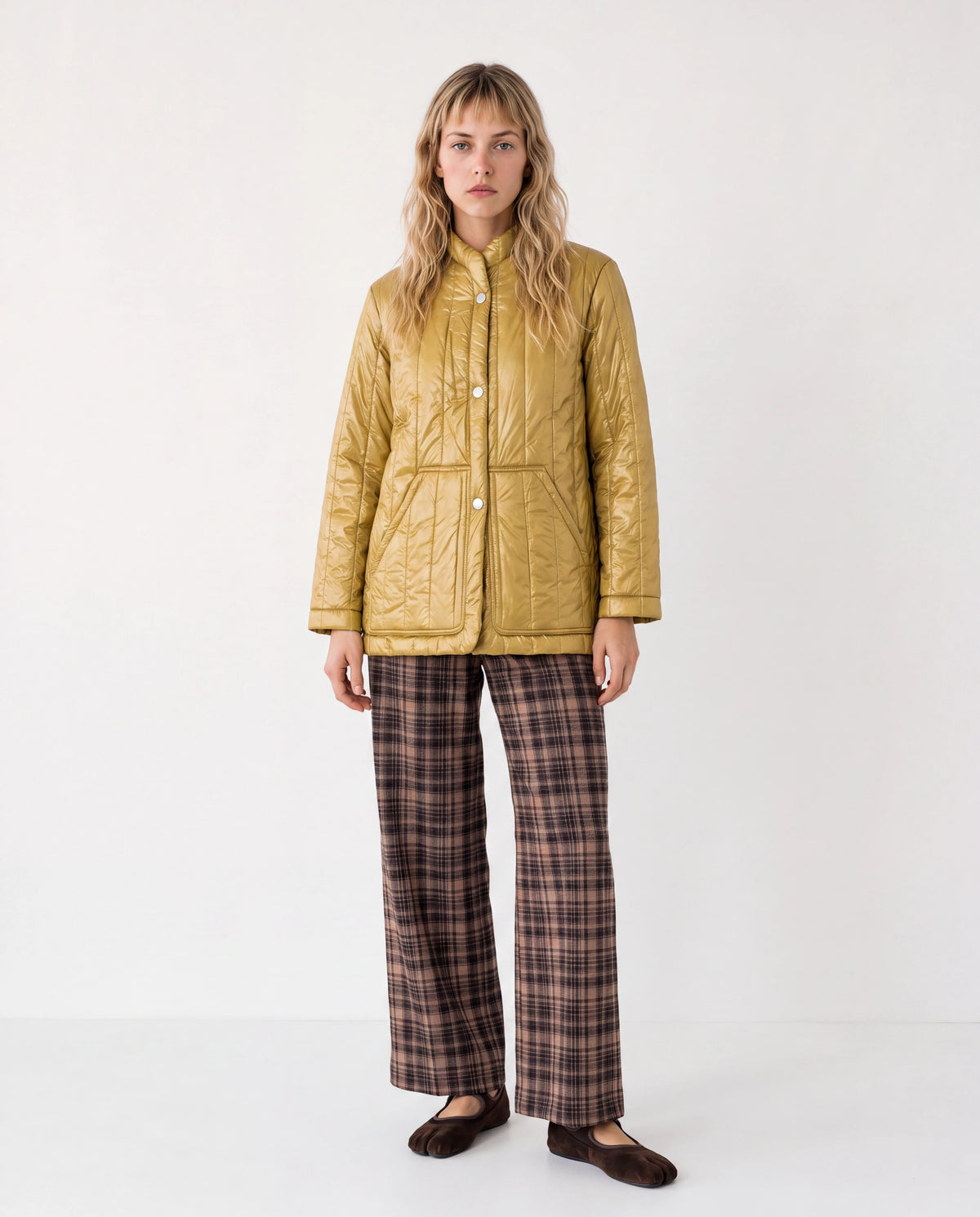 Chaqueta corta acolchada color ocre con botones frontales y cuello alto.